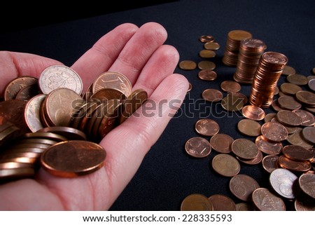 business and money saving concept - close up of female hand with euro cents and column of money