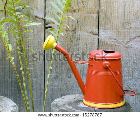 Flower watering can sitting against a cabin wall.