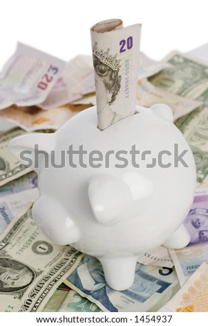 piggy bank on top of a pile of assorted world notes