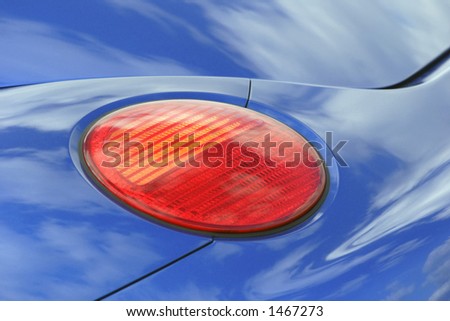 cloud reflections on rear of car with brake light