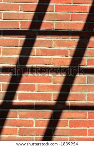 red brickwall and shadow of pergola
