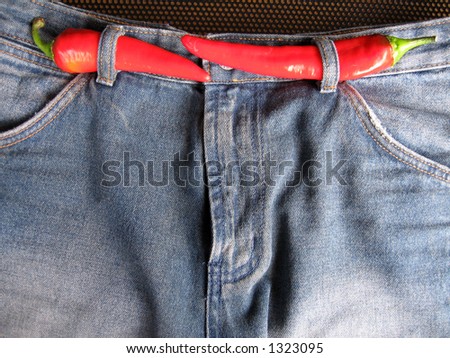A pair of fashionable hot denim jeans. The red chilies are used as a concept to depict the denim is of the current fashion trend.