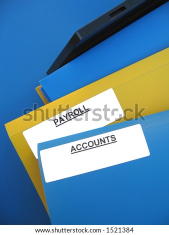Blue and yellow folders sitting on an office tray. One folder is labeled â€œPAYROLLâ€�. Another folder is labeled â€œACCOUNTSâ€�.