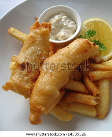 Gourmet fish and chips with a slice of lemon and tartar sauce.