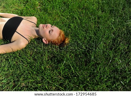 Beautiful girl relaxing lying in the field. Beauty Model Woman Face with freckles.