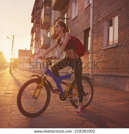 Young beautiful slim woman outdoors portrait with bike