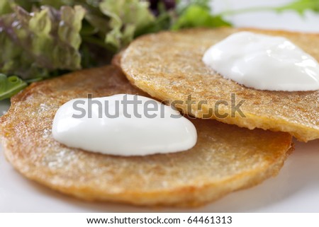 Close up of potato pancakes with sour cream