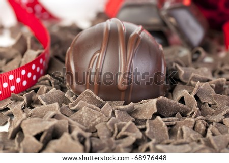 Gourmet chocolate with chocolate flakes and red ribbon.