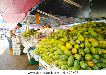KELANTAN, MALAYSIA-JUN 01: An unidentified street vendor prepares his fruits stalls street market in Kota Bharu on Jun 01, 2013 in Kelantan, Malaysia. Most of the fruits are imported from Thailand