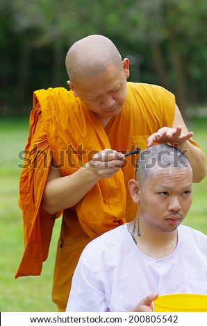 CHONBURI, THAILAND - JUNE 15 : Thai man gets his head shaved by a monk during a Buddhist ordination ceremony on June 15, 2014 in Chonburi, Thailand.