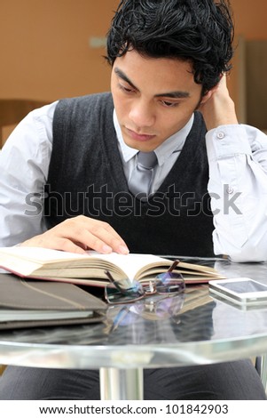 Businessman reading a book while neck pain