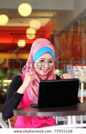 A beautiful young muslim girl was so excited with laptop
