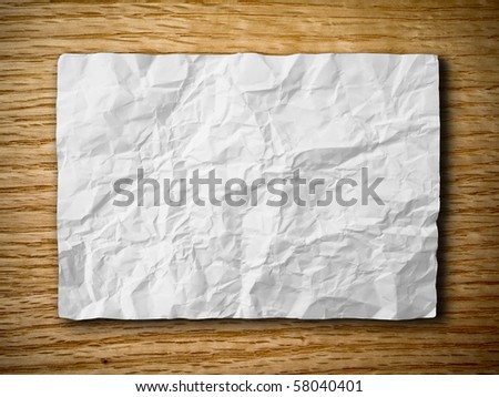 White crumpled paper on red oak wood background