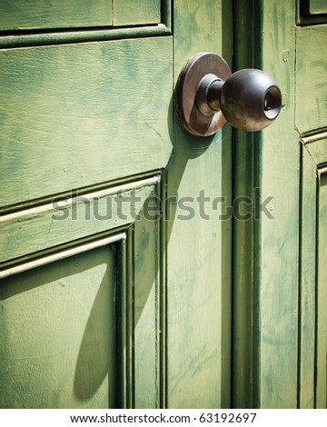 Old iron doorknob on old Green wood door