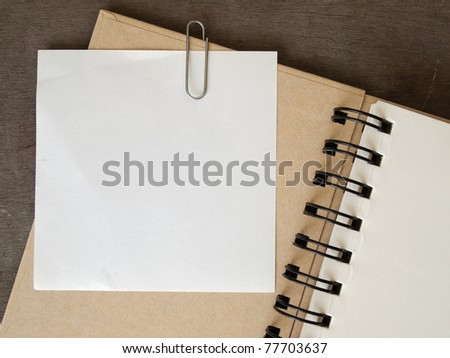 White note paper clip on brown cover note book