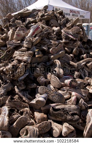 POCONO MANOR, PA - APR 29: A mountain of muddy shoes that were donated after the Tough Mudder event on April 29, 2012 in Pocono Manor, Pennsylvania. The course is designed by British Royal troops.
