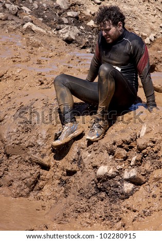 POCONO MANOR, PA - APR 29: A man sits on the banks before entering a mud pit at Tough Mudder on April 29, 2012 in Pocono Manor, Pennsylvania. The course is designed by British Royal troops.