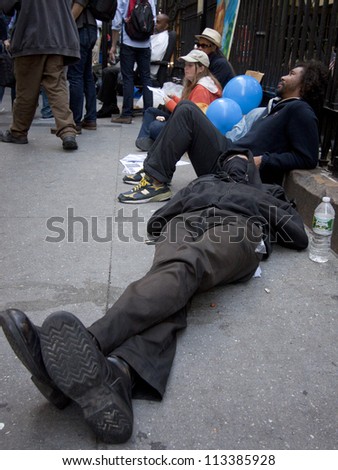 NEW YORK - SEPT 17: A protester sleeps on the sidewalk in front of Trinity Church on the 1yr anniversary of the Occupy Wall St protests on September 17, 2012 in New York City, NY.