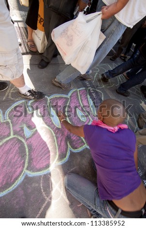 NEW YORK - SEPT 17: A protester writes with chalk on the sidewalk in front of Trinity Church on the 1yr anniversary of the Occupy Wall St protests on September 17, 2012 in New York City, NY.