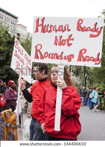 NEW YORK-MAY 25: At the March Against Monsanto in Union Square a protestor holds a sign that says \'Human Ready Not Roundup Ready\' in a global movement against GMO\'s on May 25, 2013 in Manhattan.