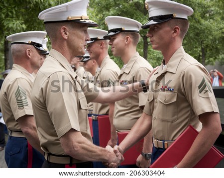 NEW YORK - MAY 23, 2014: Marine Lt. General William Faulkner shakes the hand of a U.S. Marine participating in the re-enlistment and promotion ceremony at the National September 11 Memorial site.