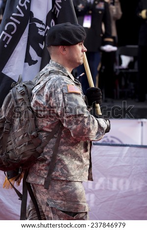 NEW YORK - NOV 11, 2014: A US vet in uniform carries the black and white Wounded Warrior Project flag as he marches in the 2014 America's Parade on Veterans Day in New York City on November 11, 2014.