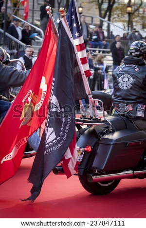 NEW YORK - NOV 11, 2014: A US vet rides a Harley Davidson motorcycle with the American, USMC, and POW / MIA Flags attached to the back during the 2014 America\'s Parade on Veterans Day on Nov 11, 2014.