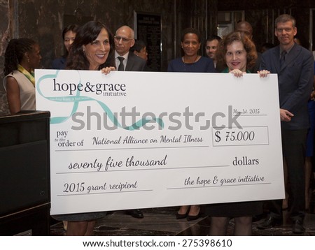NEW YORK - MAY 5, 2015: hope & grace initiative board member and CMO of Coty Skincare Jill Scalamandre presents Exec Dir of NAMI, Mary Giliberti a check at the ceremony in the Empire State Building.