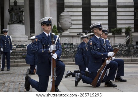 NEW YORK - MAY 21 2015: Members of the US Coast Guard Ceremonial Honor Guard Silent Drill Team kneel down during a drill next to the New York Public Library in Bryant Park during Fleet Week NY 2015.