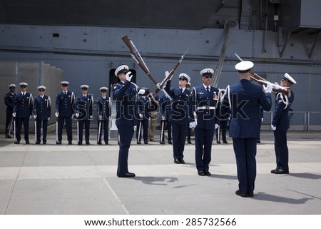 NEW YORK - MAY 22 2015: The US Coast Guard Ceremonial Honor Guard Silent Drill Team  perform an air-toss movements of rifles with fixed bayonets on Pier 92 next to the Intrepid during Fleet Week NY.