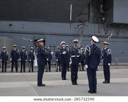 NEW YORK - MAY 22 2015: The US Coast Guard Ceremonial Honor Guard Silent Drill Team perform an air-toss movements of rifles with fixed bayonets on Pier 92 next to the Intrepid during Fleet Week NY.