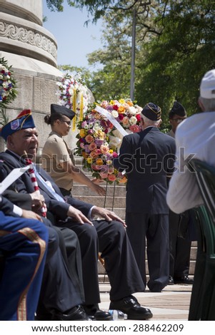 NEW YORK - MAY 25 2015: A US veteran helps lay a wreath of flowers at the annual Memorial Day Observance service held at the Soldiers and Sailors Monument in Manhattan during Fleet Week NY 2015.