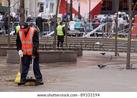 NEW YORK - NOV 17: An unidentified worker cleans Zuccotti Park on the 'Day of Disruption' on November 17, 2011 in New York City, NY. Protesters had occupied the park for 2 months before being evicted.