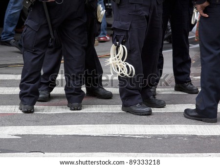 NEW YORK - NOV 17: Police officers equipped with handcuffs stationed on Wall St near the New York Stock Exchange during the Occupy Wall Street rally on November 17, 2011 in New York City, NY.