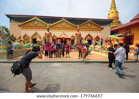 PENANG, MALAYSIA- FEB 2, 2014 : Family taking group photo outside the main temple of chayamangalaram, a famous siamese temple in Penang Malaysia during Chinese New Year 2014.
