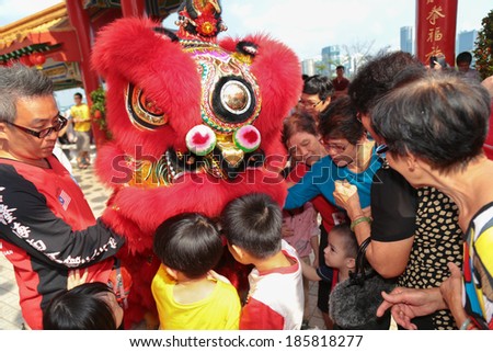 KUALA LUMPUR, MALAYSIA- FEB 9, 2014 : Youngs and olds taking goodies from lion dance as a gesture of good luck at Thean Hou temple during Lunar Chinese New Year.