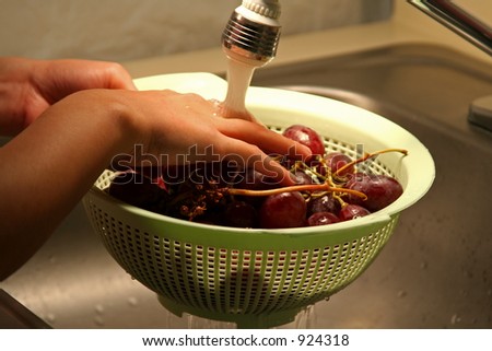 Washing fruit under running tap water