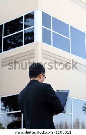 Businessman at work using laptop outside office