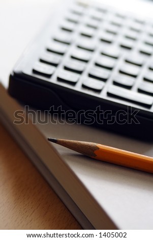 A pencil, calculator and book, for business/money concept