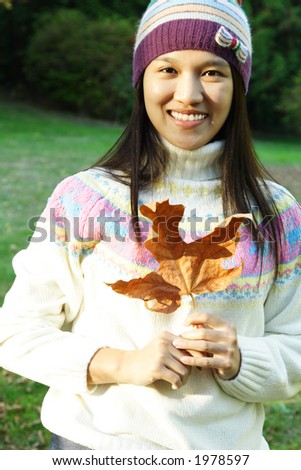 A pretty woman holding an autumn/fall leaf