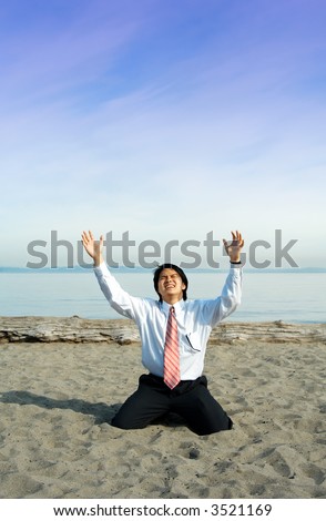 A stressed businessman crying and kneeling on the beach