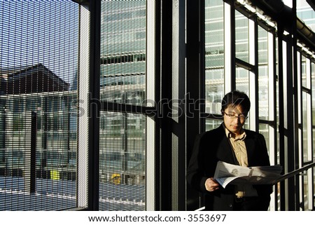 A businessman reading financial newspaper on a train station