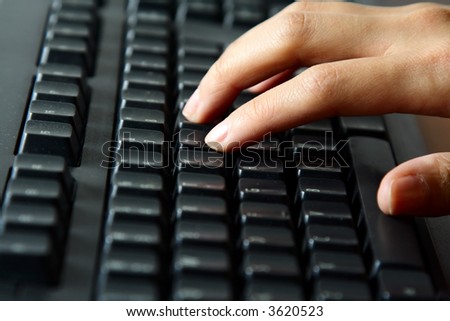 A businesswoman typing on a black keyboard