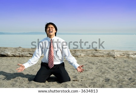 A stressed and frustrated businessman screaming on the beach