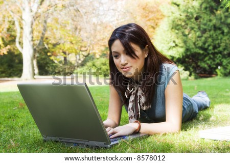 A beautiful college student working on her laptop on campus
