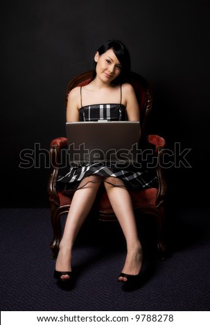 A portrait of a beautiful woman working on laptop in a retro setting