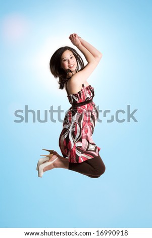 A beautiful asian woman jumping for joy