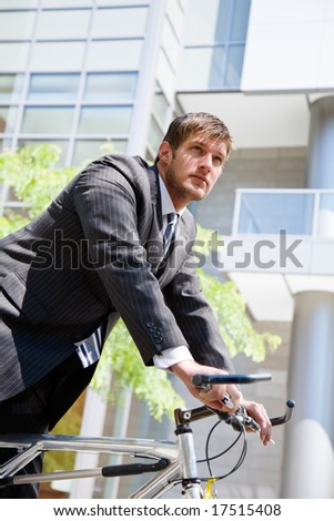 A caucasian businessman riding a bike to work, can be used for green or gas savings concept