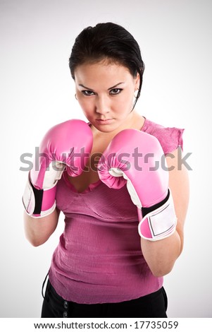 A shot of a businesswoman wearing a pair of boxing gloves
