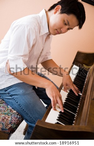 A shot of an asian man playing piano
